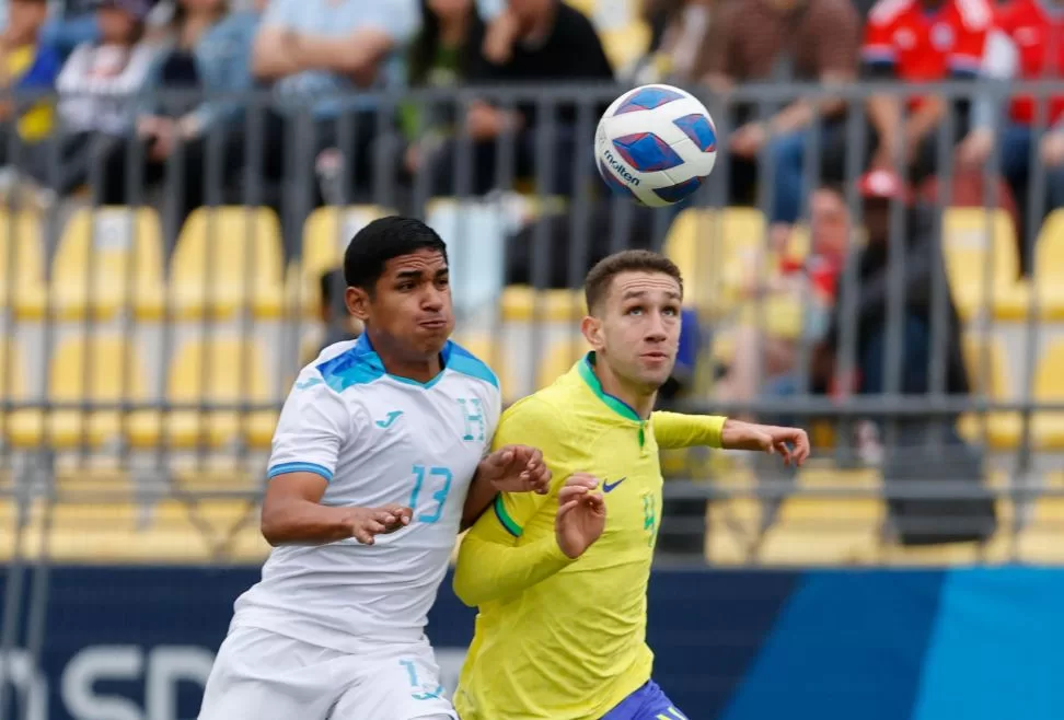 Arthur Chaves (d) de Brasil disputa un balón con Marco Aceituno de Honduras hoy, en un partido de fútbol durante los Juegos Panamericanos 2023 en Santiago (Chile). EFE/ Elvis González